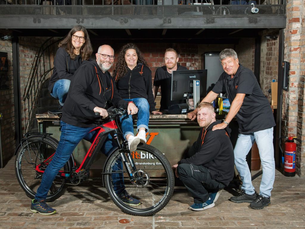 Eine Gruppe von Menschen, die lächelnd mit einem e-bike posieren