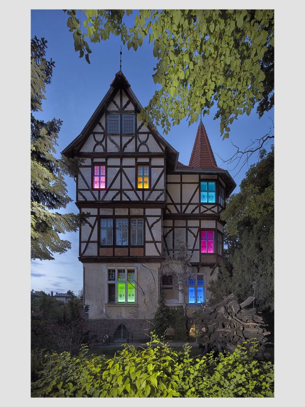 3 stöckiges Fachwerkhaus mit bunt beleuchteten Fenstern