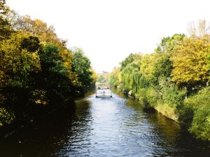 Eine Fähre fährt auf einem Berline Kanal zwischen Uferböschungen