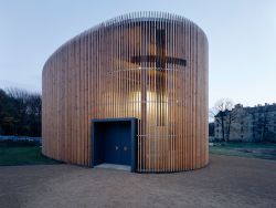Eine moderne ovale Kapelle aus Holzlatten auf Kiesboden